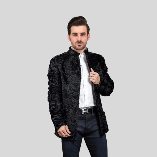 Man wearing a black textured jacket over a white shirt on a gray background