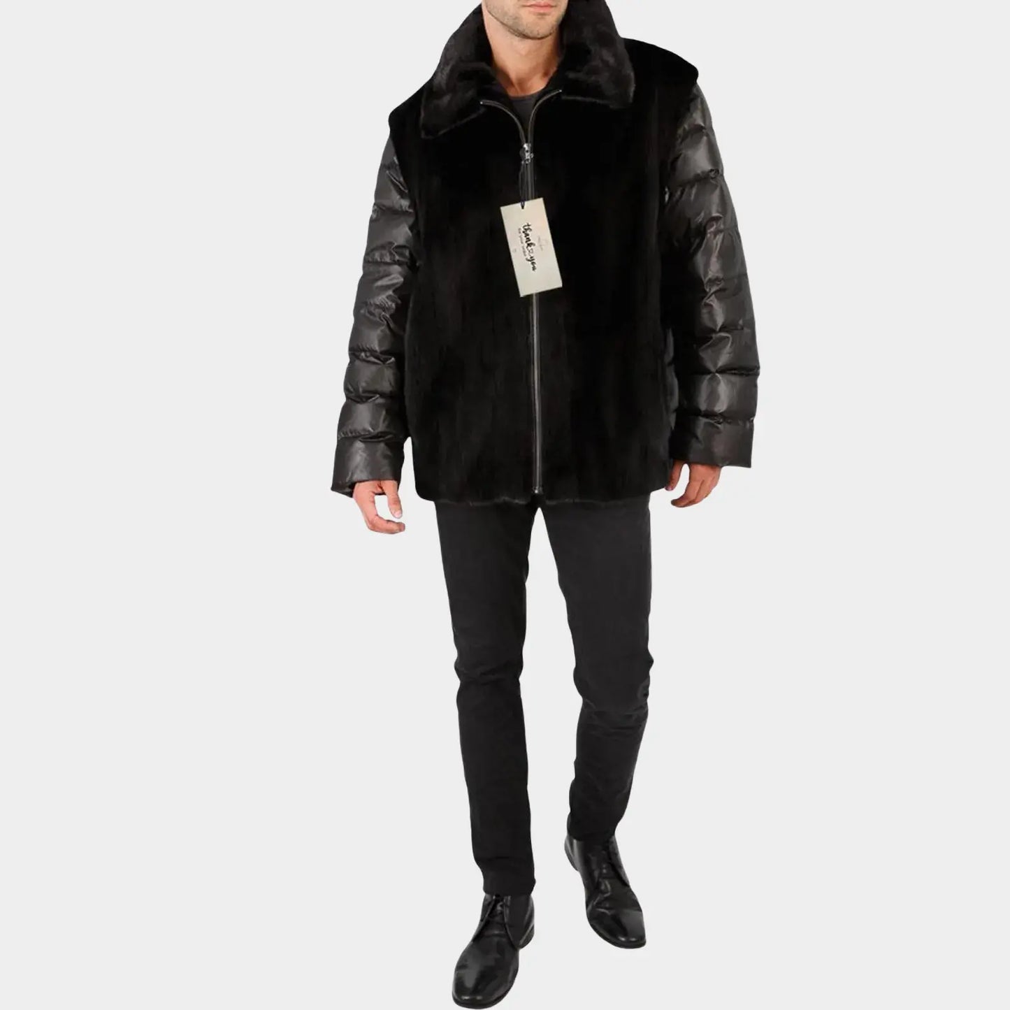 Man wearing a black puffer jacket with leather sleeves on a white background