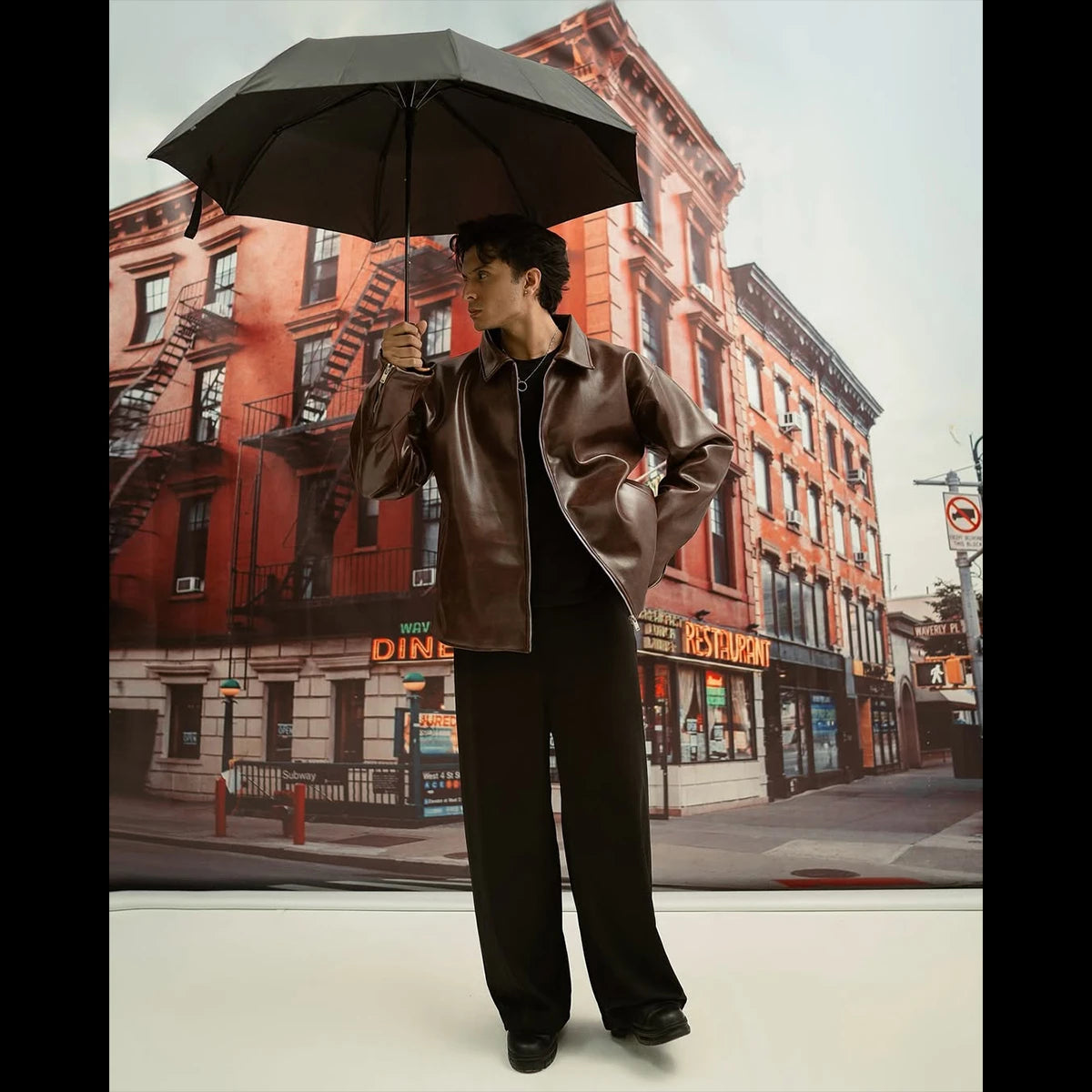 Person holding an umbrella in front of a cityscape background