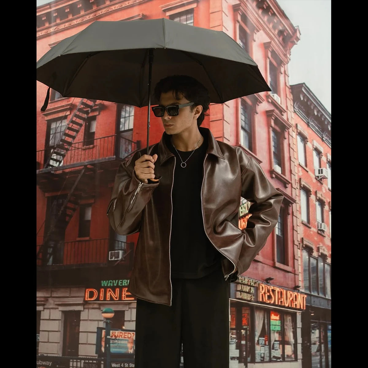 Person holding an umbrella in front of a city street backdrop with buildings and signs.