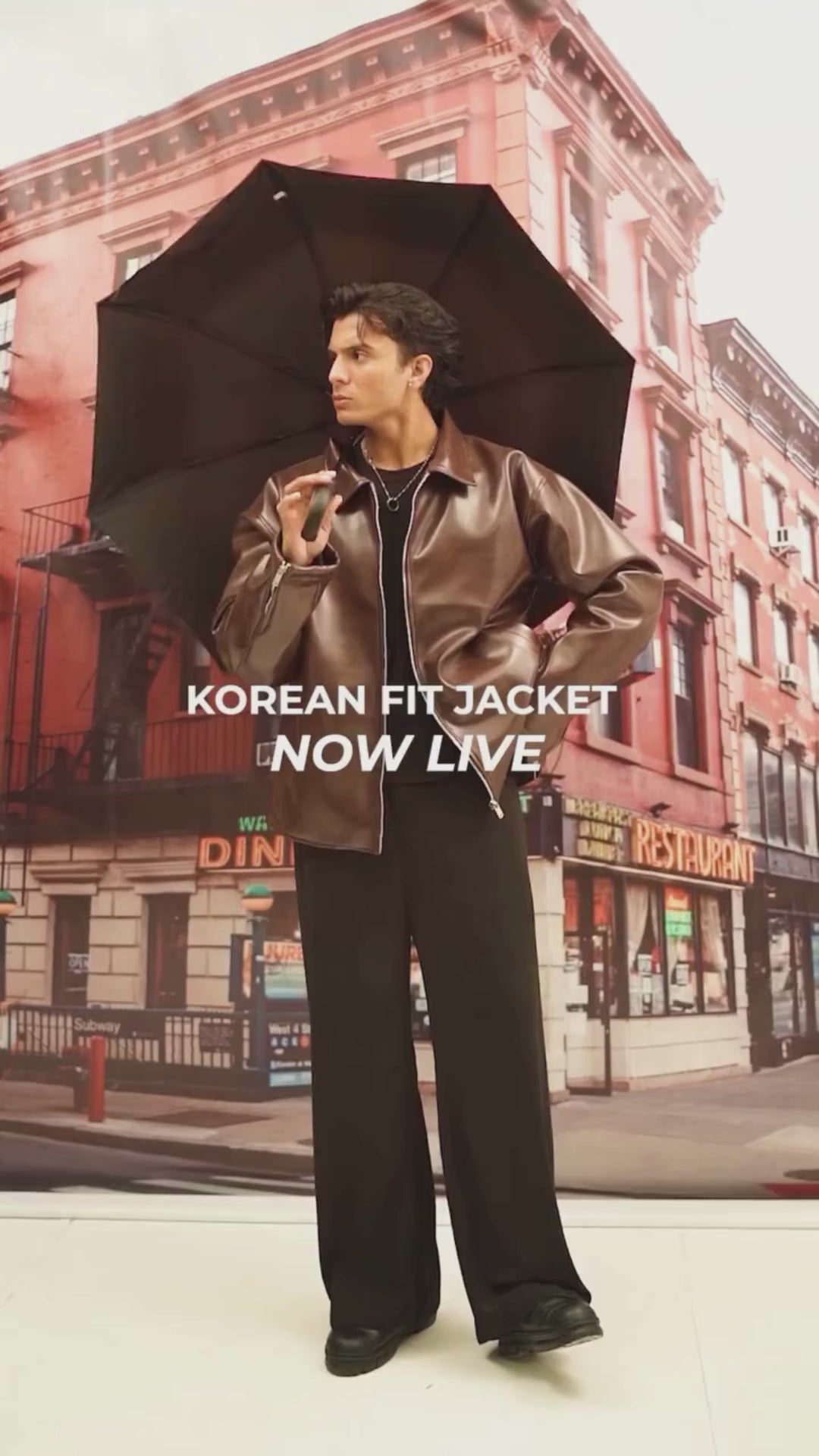 Person holding an umbrella in front of a city street backdrop with buildings and signs.