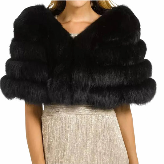 Black fur shrug worn over a silver dress on a white background
