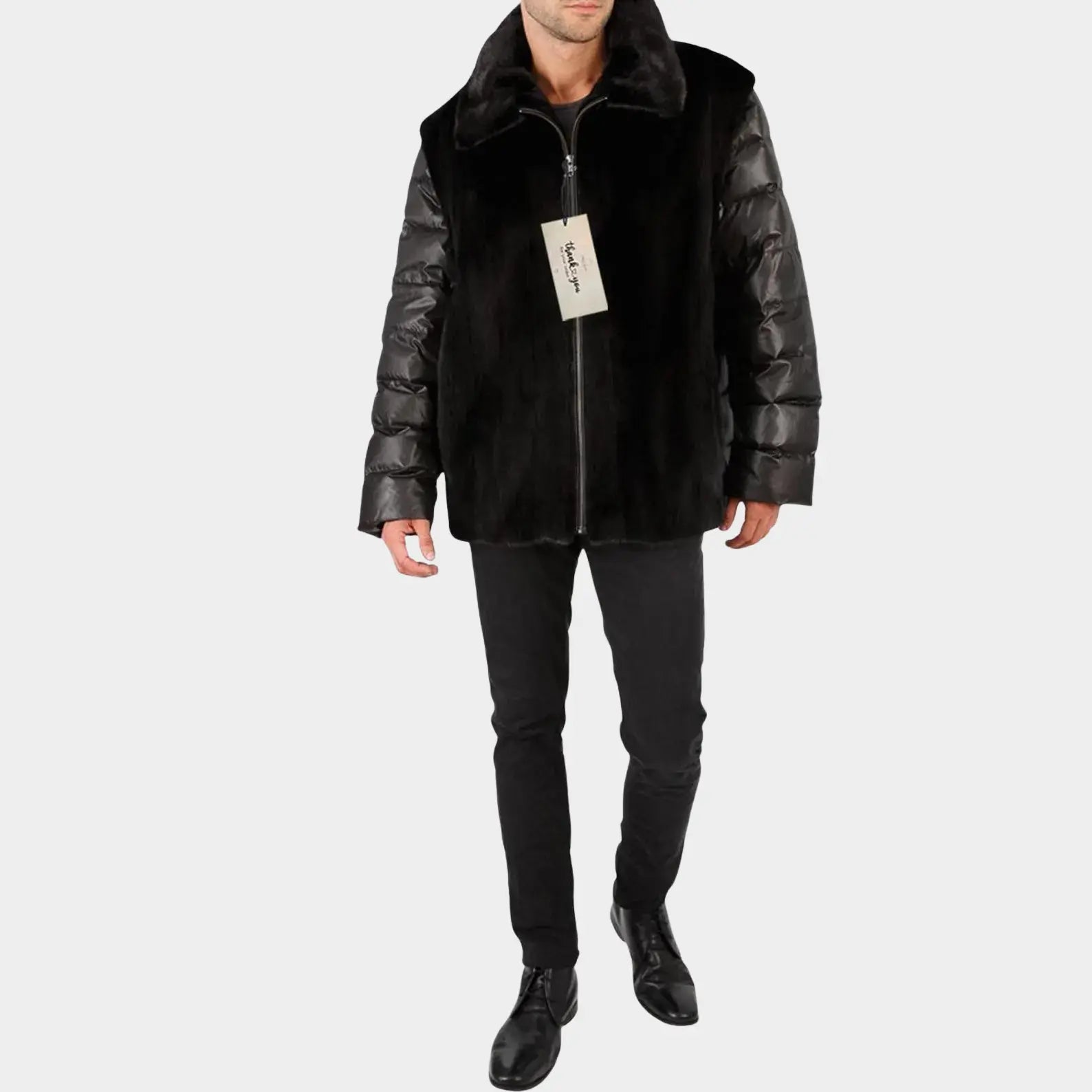 Man wearing a black puffer jacket with leather sleeves on a white background
