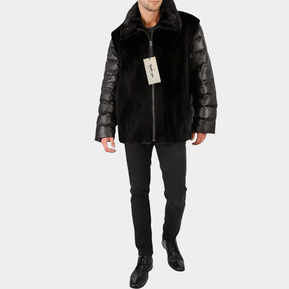 Man wearing a black puffer jacket with leather sleeves on a white background