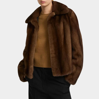Brown fur jacket worn by a person on a white background