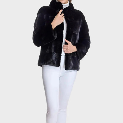 Black fur jacket worn by a person on a white background